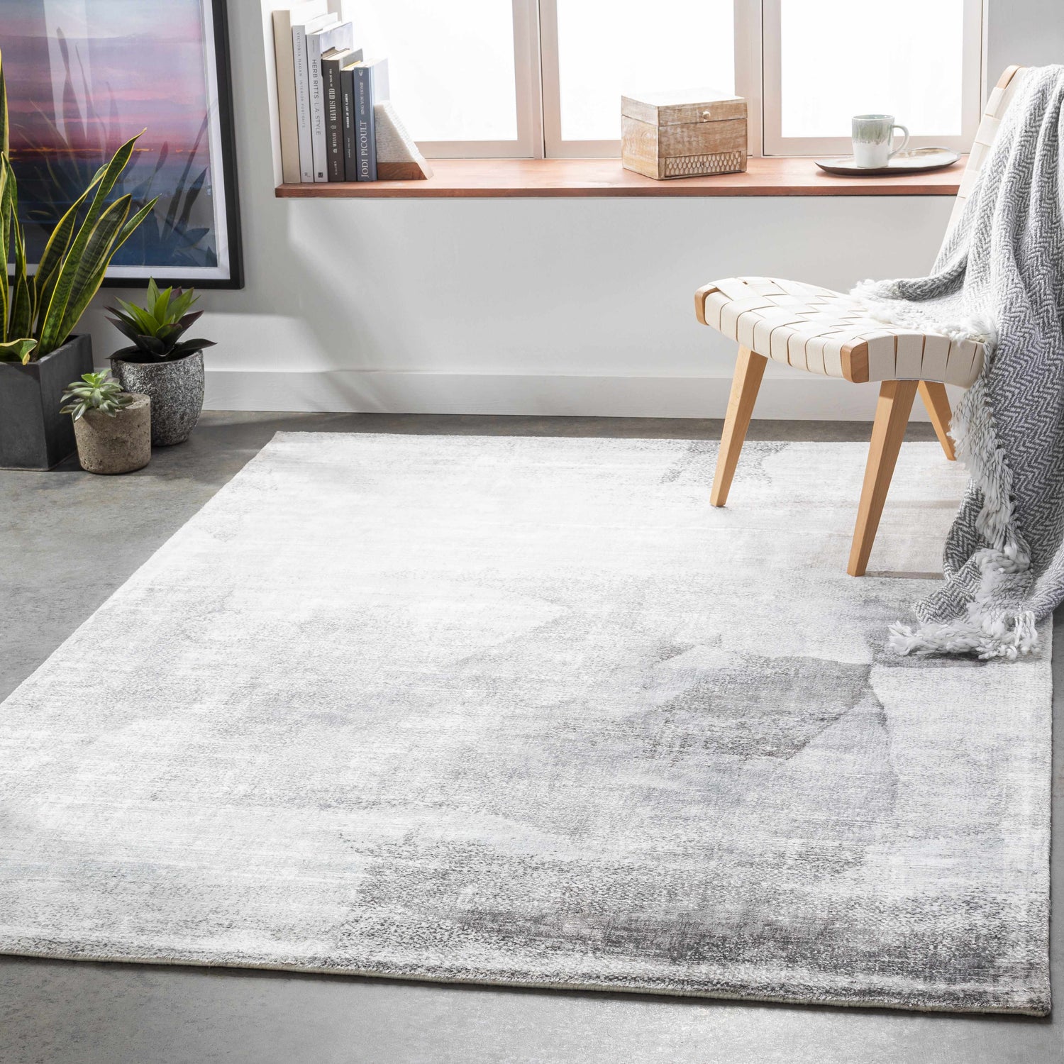 Minimalist living room scene with gray McDowall Viscose Area Rug, woven chair, plants, and natural light. Roomscene-Rectangle