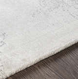 Close-up of the McDowall Viscose Area Rug showing its off-white color, soft texture, and hand-loomed construction. Texture