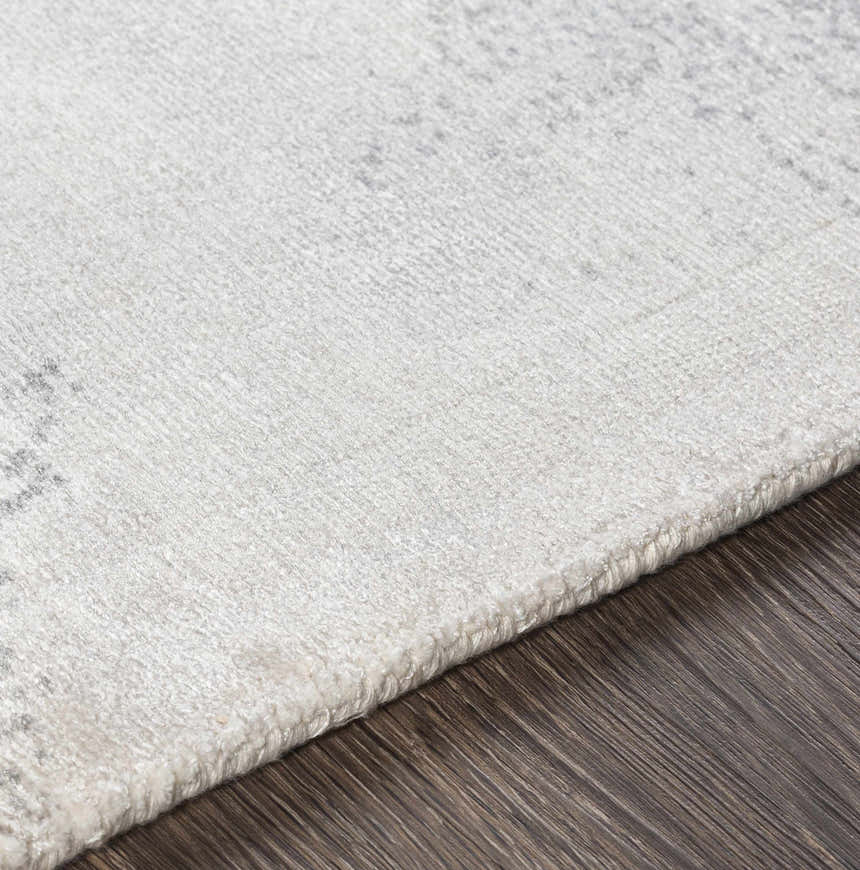 Close-up of the McDowall Viscose Area Rug showing its off-white color, soft texture, and hand-loomed construction. Texture