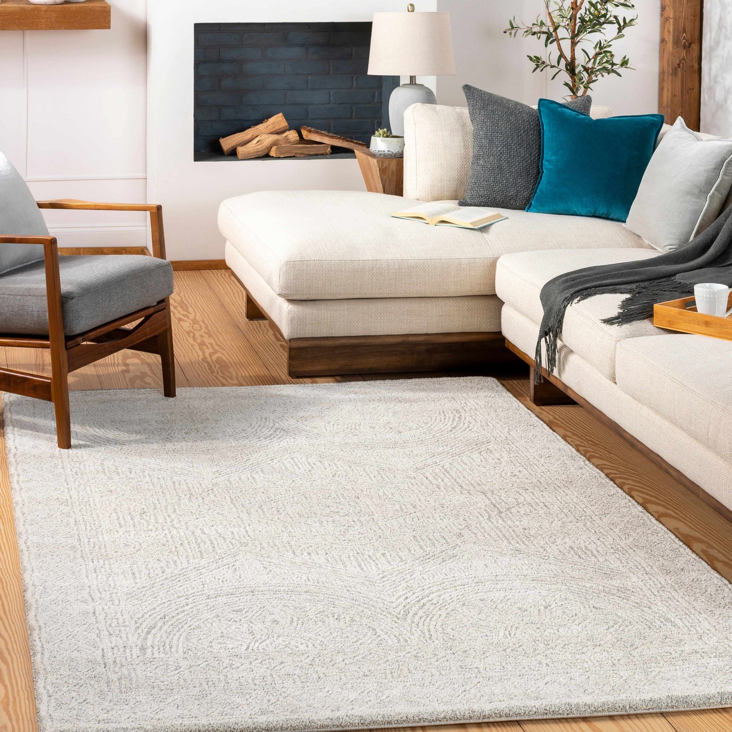 Living room scene with a light beige Middleville Luxe Rug, cream sofa, gray chair, and fireplace. Contemporary style. Roomscene-Rectangle