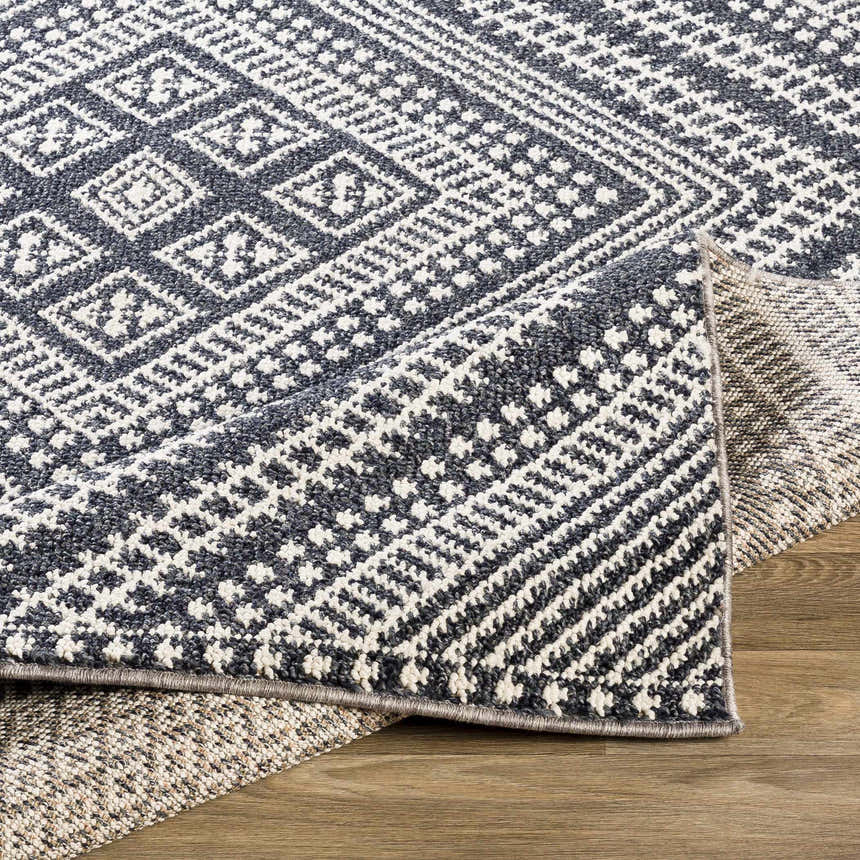 Close-up of the Madison Black&White Area Rug showing the bohemian diamond pattern and jute texture. Fold