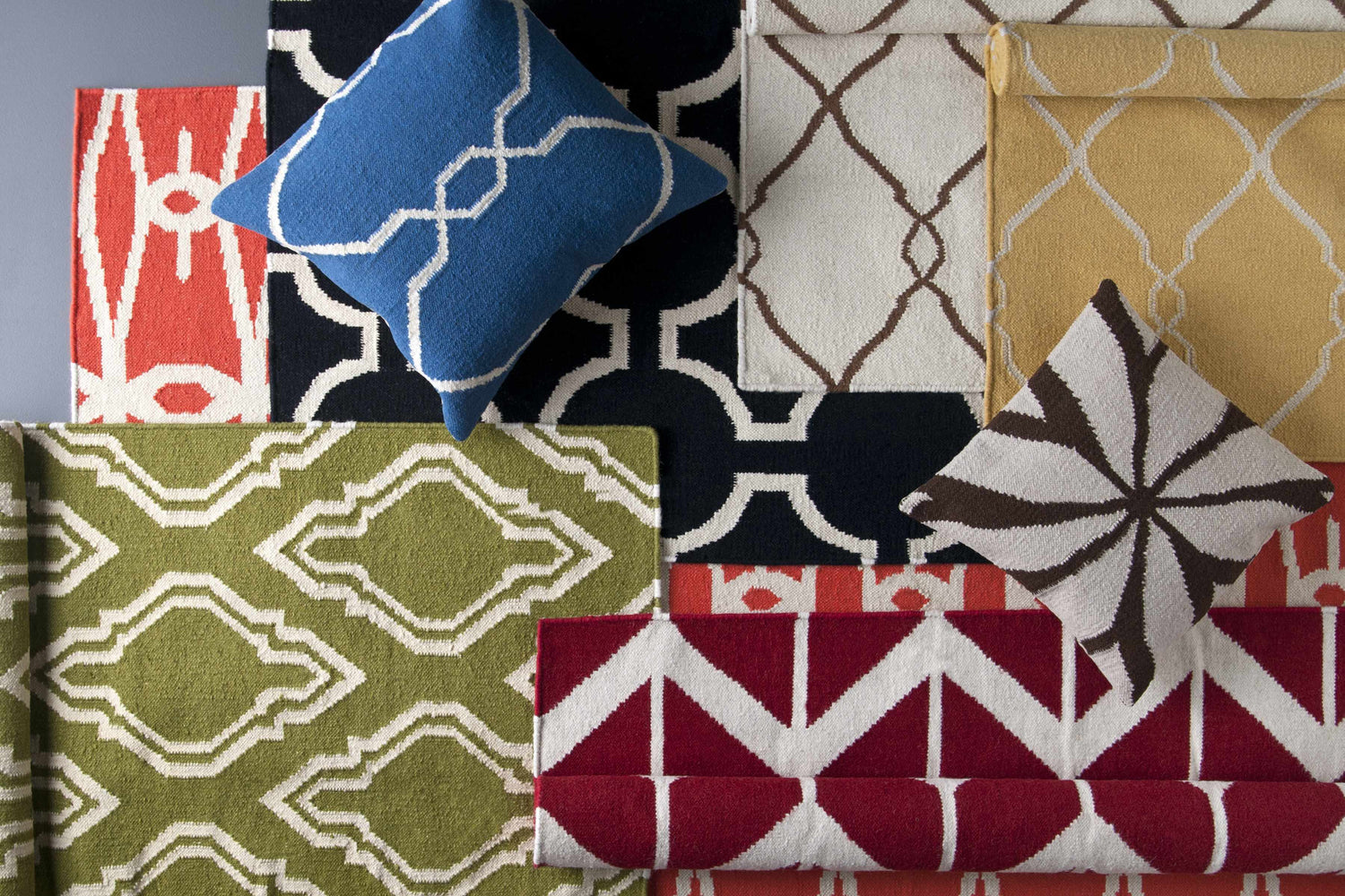 Melbeta Area Rug assortment. Hand-woven wool rugs in contemporary patterns and colors: red, green, black, yellow, and blue. Styleshot