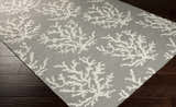 Close-up of the Merchantville Area Rug. Ivory coral pattern on light gray 100% wool rug. Hand woven texture. Corner
