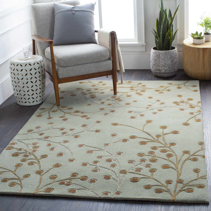 Living room scene with a Sage Elsu Area Rug, gray chair, side tables, and plants. Floral pattern rug in sage and brown. Roomscene-Rectangle
