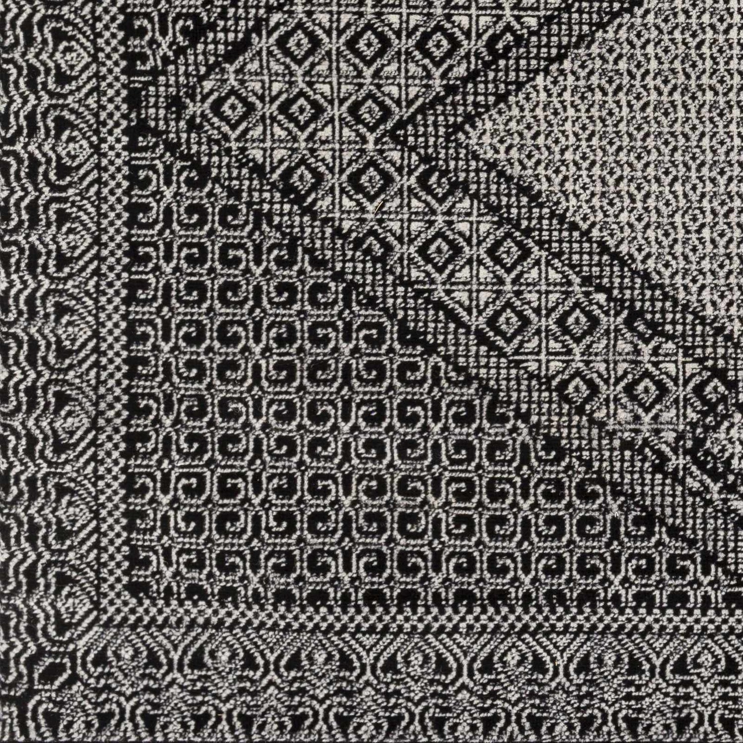 Close-up of the Merkez Area Rug, showcasing its geometric, black and natural gray, machine-woven design. Swatch