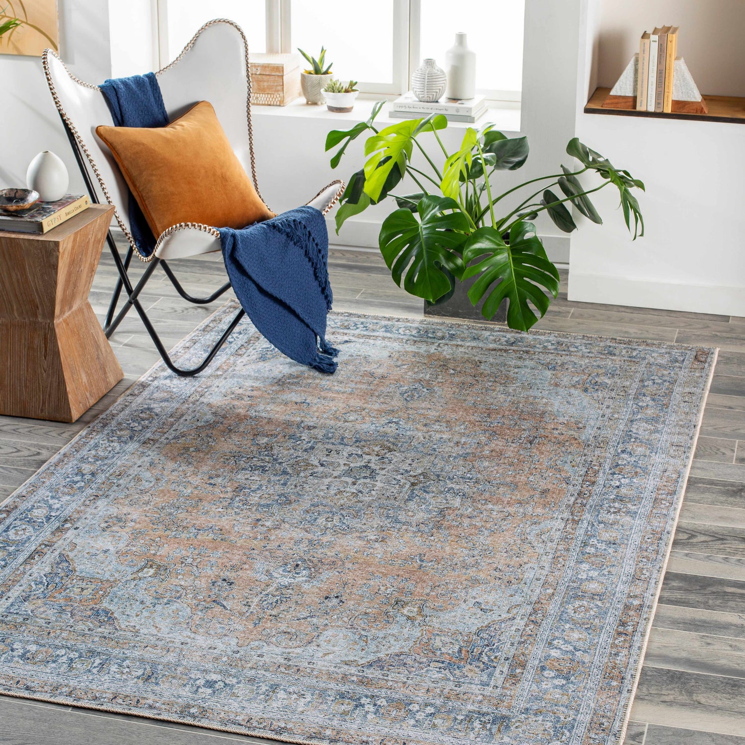 Living room with a white chair and the Mianay Washable Area Rug in beige, blue, and light gray. Roomscene-Rectangle