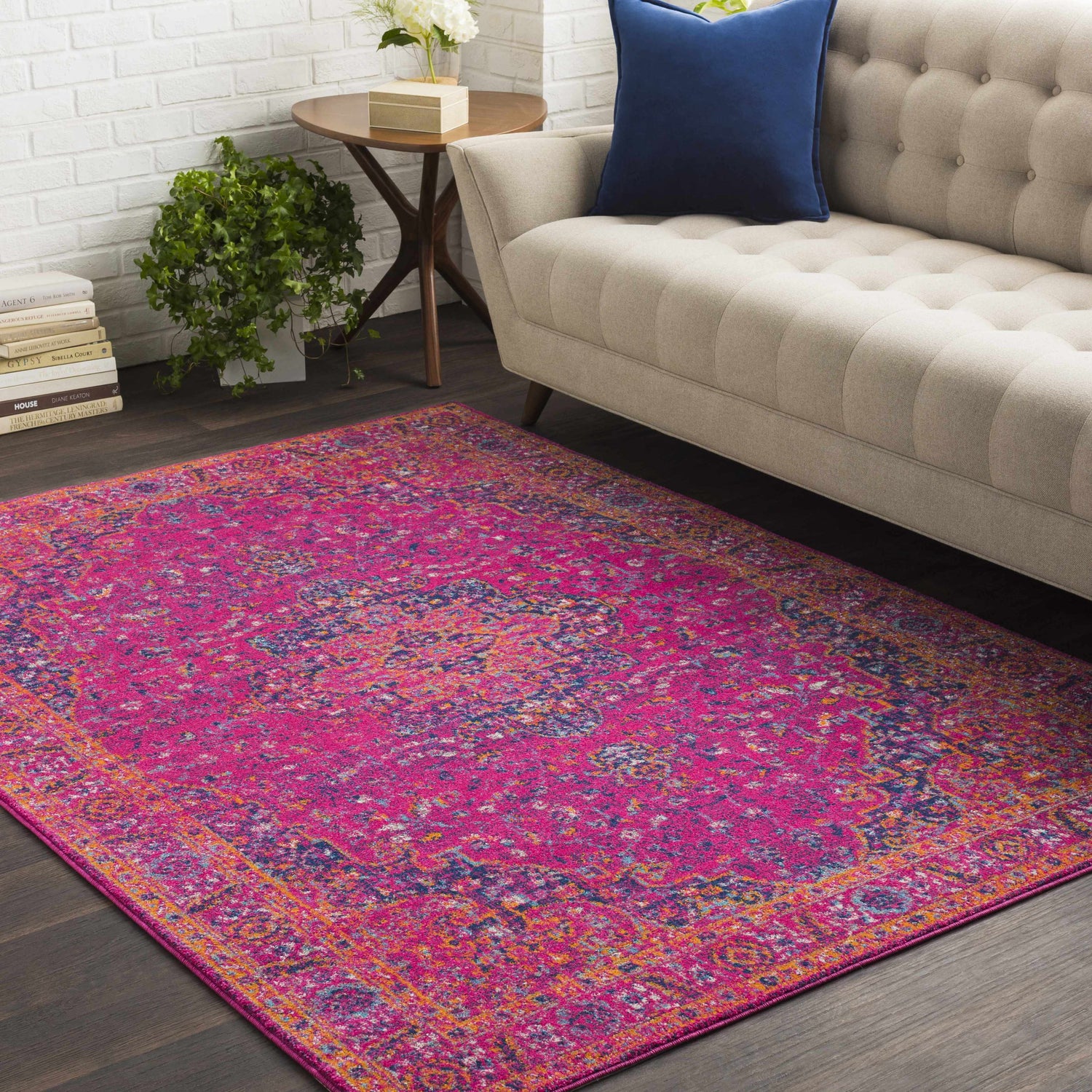 Living room scene with a Milliken Magenta Area Rug, beige sofa, and white brick wall. Roomscene-Rectangle