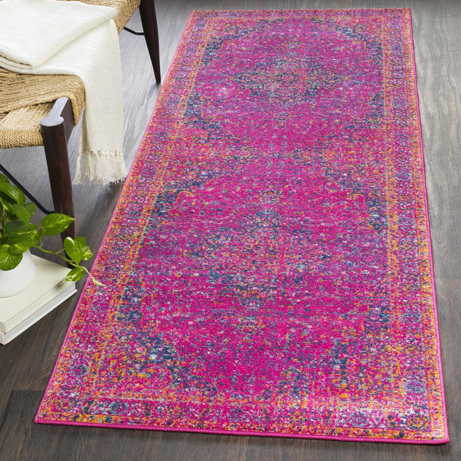 Bohemian style runner rug. Milliken Magenta Area Rug in a hallway with a chair, blanket, and plant. Roomscene-Runner