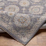 Close-up of the Mimarsinan Thick Luxe Statement Rug showing its gray, beige, and brown oriental pattern and soft texture. Fold