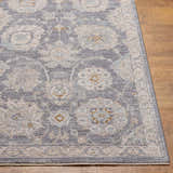 Close up of the Mimarsinan rug showing its gray, beige, and brown oriental pattern on wood flooring. Front