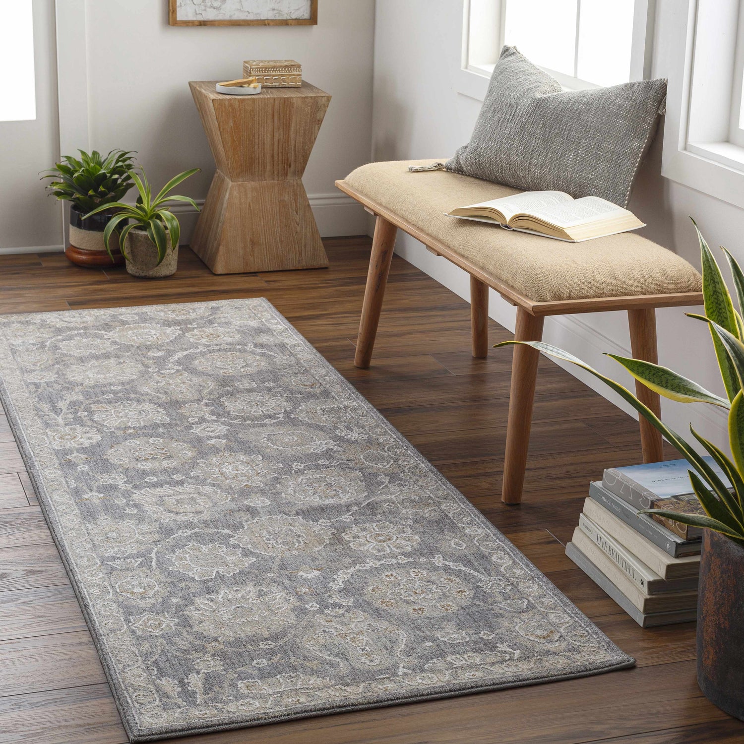 Entryway with a gray Mimarsinan Traditional rug, wood bench, books, and plants for a cozy, inviting feel. Roomscene-Runner