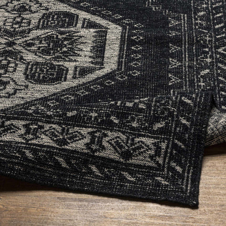 Close up of the black and cream Minapan Premium Area Rug showing the traditional hand-knotted design. Fold