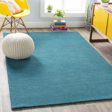 Bright living room with a solid teal Brockton wool rug, yellow chair, and modern cabinet. Roomscene-Rectangle