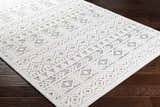 Close-up of the Mirani 3D Outdoor Area Rug in charcoal and light beige with a geometric bohemian pattern. Corner