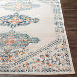 Close-up of the Mistissini Area Rug, showcasing its cream, blue, and orange traditional-style pattern and soft texture. Front