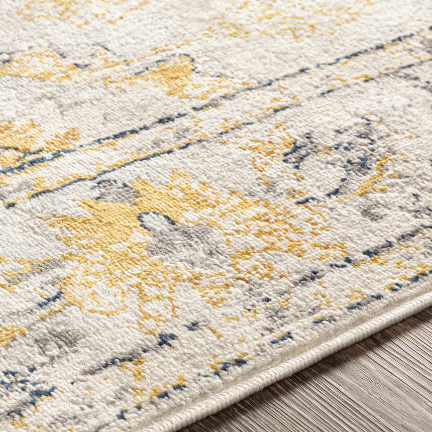 Close-up of the Mistley Area Rug showing its beige, gray, mustard, and navy bohemian pattern and machine-woven texture. Texture