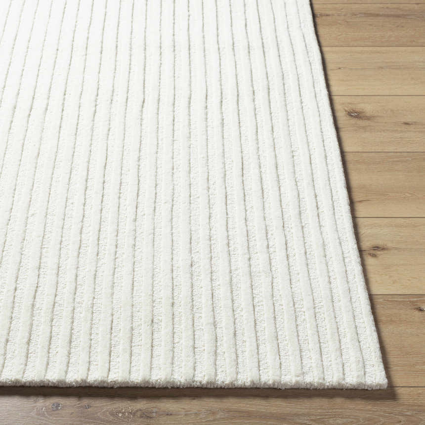 Close-up of the cream Missa Area Rug showing its textured, vertical striped design and wool pile on a wood floor. Front