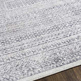 Close-up of the Mandaon Area Rug, a machine-woven rug with a charcoal, cream, and gray bohemian pattern. Texture
