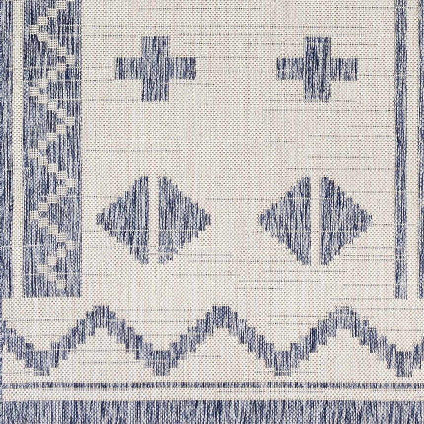 Close-up of the Mangoso Gray Area Rug showing its blue geometric pattern on an off-white woven polypropylene texture. Swatch