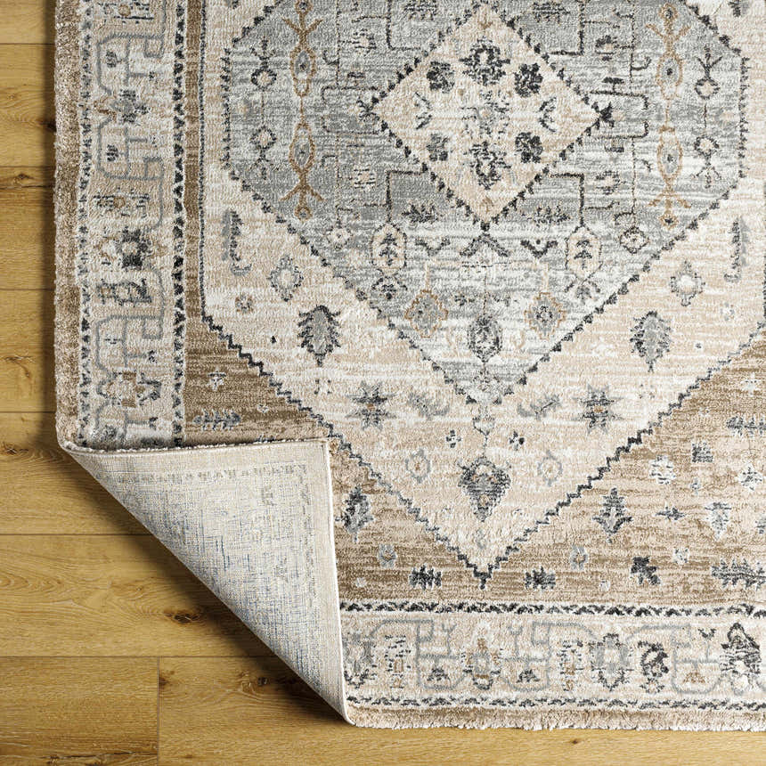 Close up of the Minal Luxe Area Rug showing the traditional pattern, dark gray and medium gray colors, and soft texture. Fold