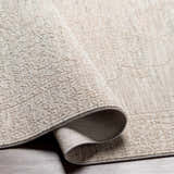 Close-up of the Monto Luxe Rug showing its cream and gray tones, textured weave, and traditional-inspired pattern. Fold