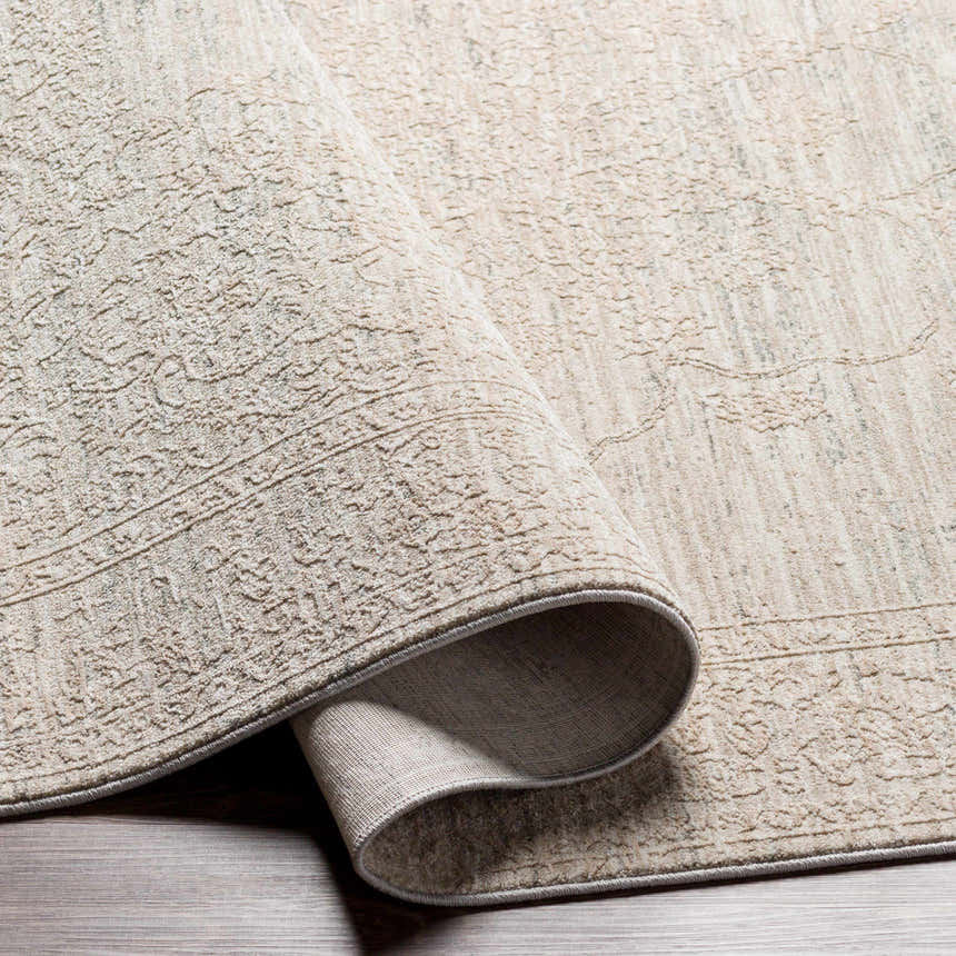 Close-up of the Monto Luxe Rug showing its cream and gray tones, textured weave, and traditional-inspired pattern. Fold