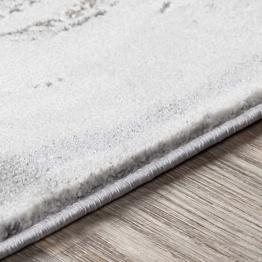 Close-up of the Moana Charcoal Marble Rug showing its soft texture, gray marble pattern, and woven edge detail. Texture