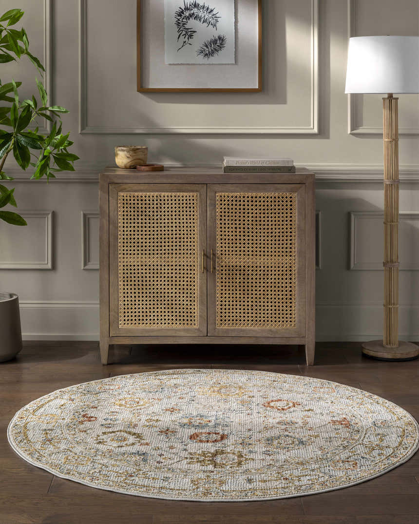 Living room scene with a round Mogul Luxe Oushak Rug in cream, brick red, denim, and tan under a cabinet. Roomscene-Round