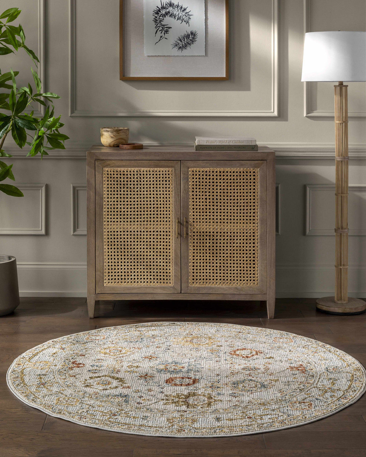 Living room scene with a round Mogul Luxe Oushak Rug in cream, brick red, denim, and tan under a cabinet. Roomscene-Round