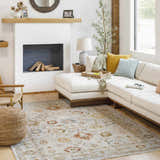 Living room scene with a cream sectional sofa and the Mogul Luxe Oushak Rug in brick red, cream, and denim. Roomscene-Rectangle