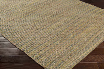Close-up of the hand woven Molus Area Rug. Natural jute rug with subtle blue and yellow woven details. Corner