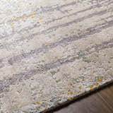 Close-up of the hand-knotted Moncure Area Rug. Features black, beige, gray, sage, and mustard hues with a contemporary design. Texture
