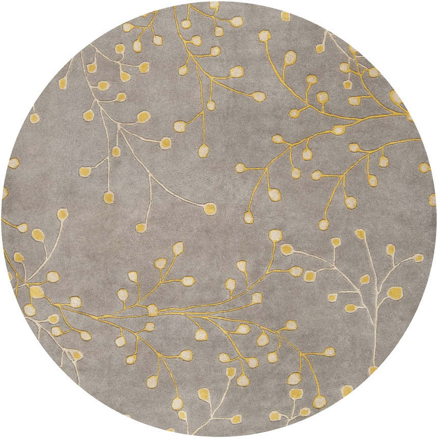 Close-up of the round Elsu Mustard Wool Area Rug featuring a delicate floral pattern in mustard and taupe on a charcoal background. Design-Round-6