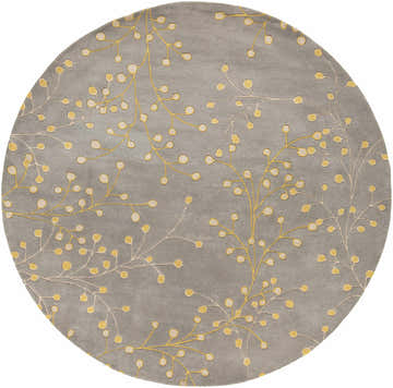 Close-up of the round Elsu Mustard Wool Area Rug, featuring a gray background and a delicate floral pattern in mustard and taupe. Design-Round-8