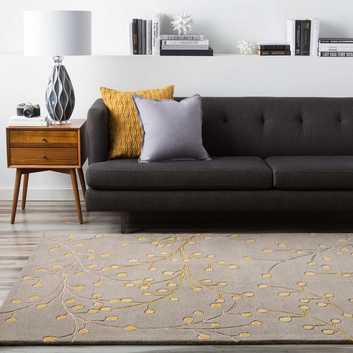 Living room scene with charcoal sofa, wood side table, and Elsu Mustard Wool Area Rug with floral design. Roomscene-Rectangle