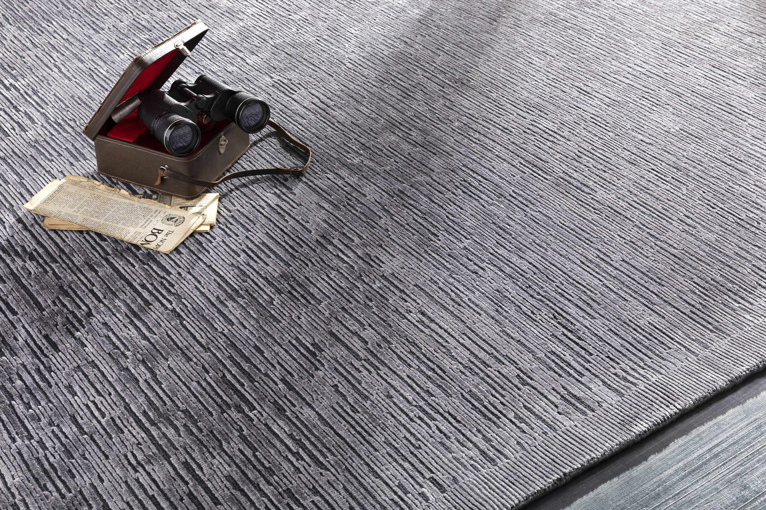 Close-up of the Motcombe Area Rug. Black and charcoal wool and silk rug with a textured, striated design. Styleshot