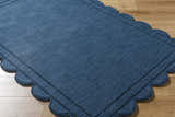 Close-up of the hand-loomed Uhuro Blue Geometric Area Rug showing its wool texture and scalloped edge detail. Corner