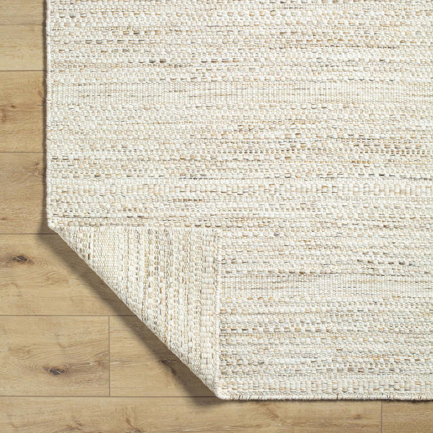 Close-up of the hand woven Moshe Area Rug, showing its peach wool texture and construction. Fold
