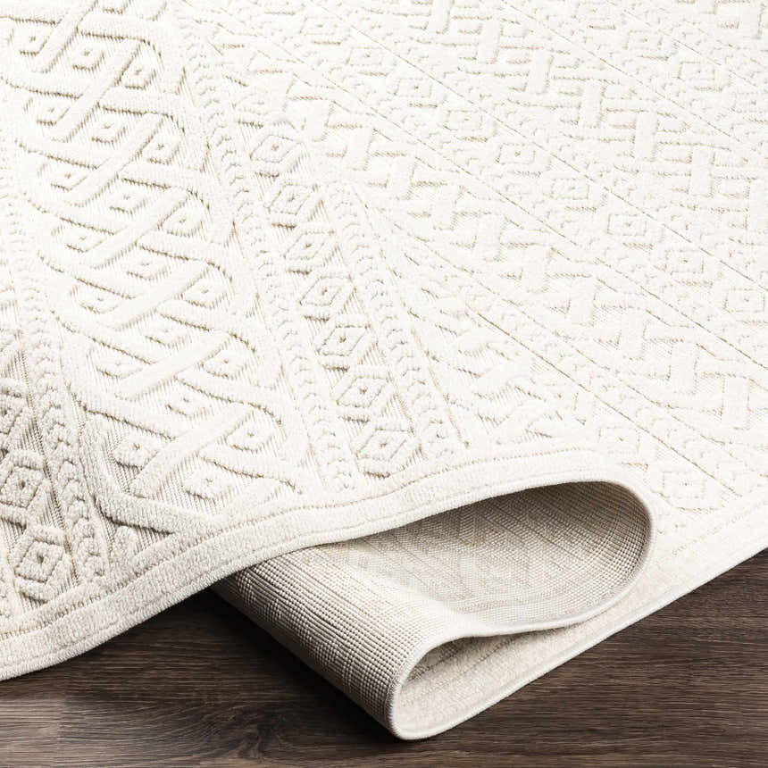 Close-up of the cream Maribyrnong 3D Outdoor Area Rug, showing its geometric design and textured pile. Fold