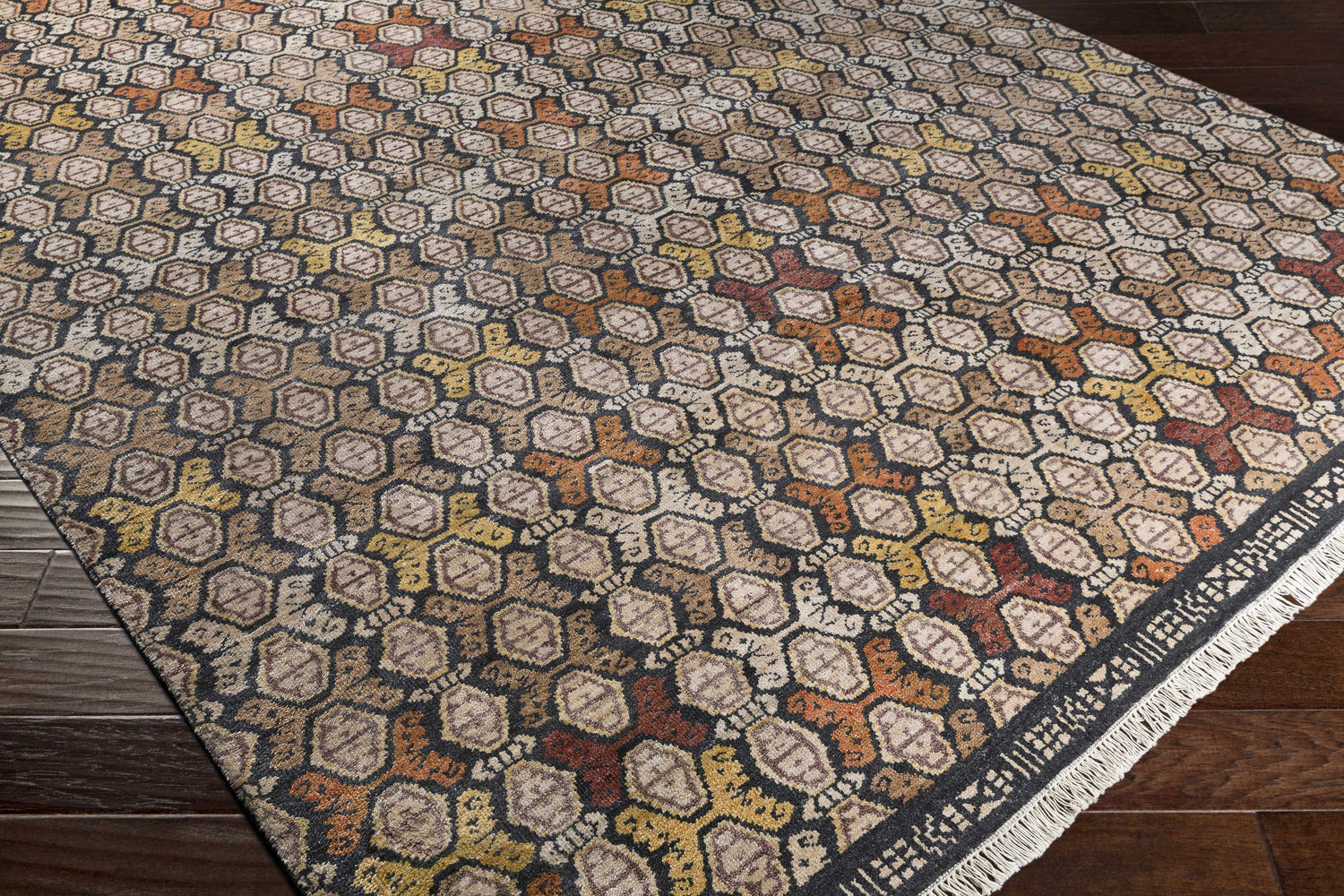 Close-up of the Mercersburg Carpet showing a geometric pattern in black, orange, beige, brown and red. Corner
