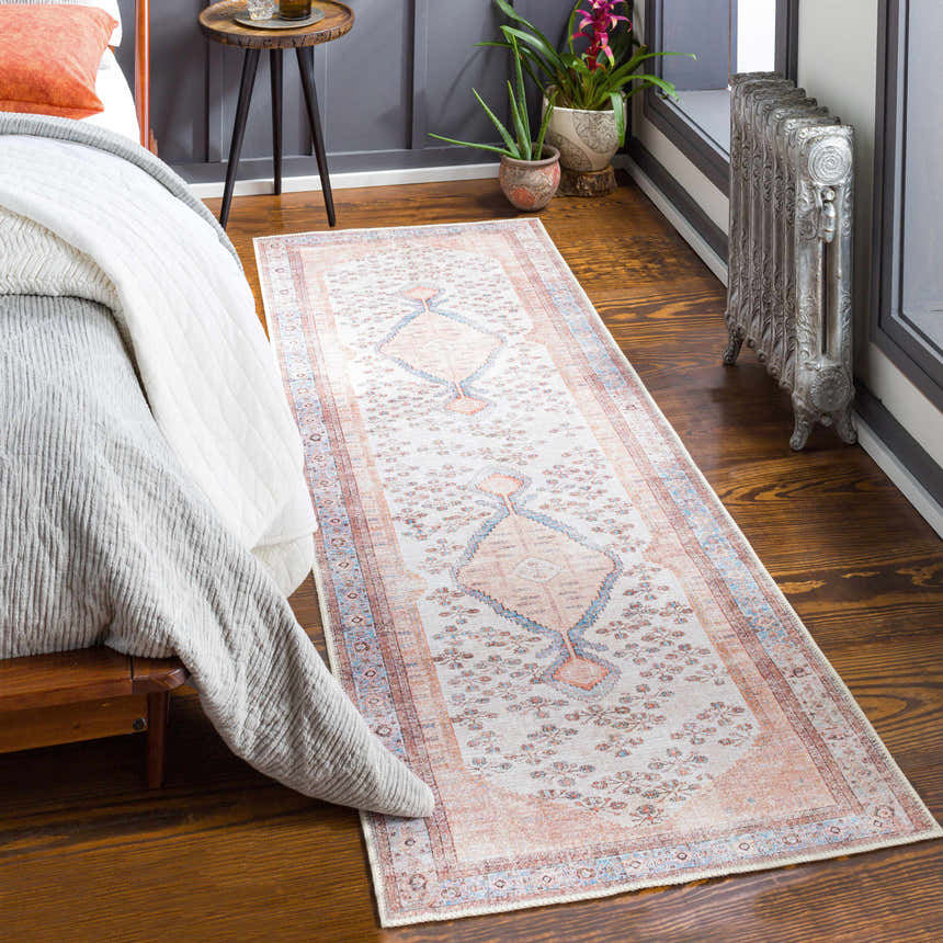 Bedroom scene with a Bohemian-style Moora Washable Area Rug in aqua, blush, and brown colors. Roomscene-Runner