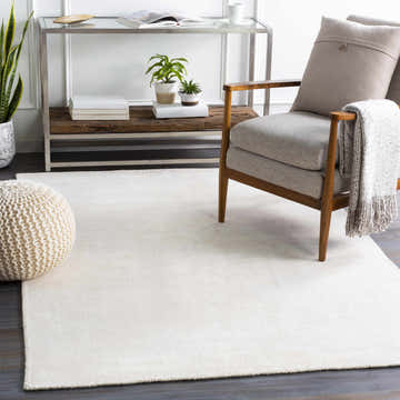 Modern living room scene with cream Merritt Area Rug, gray chair, and neutral accents. Roomscene-Rectangle