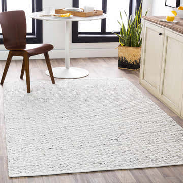 Bright kitchen scene featuring the ivory and black Martin Area Rug, a round table, and a wooden chair. Roomscene-Rectangle