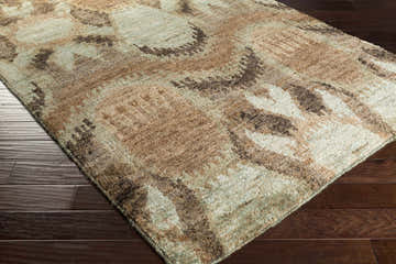 Close-up of the hand-knotted Mitchellville Jute Carpet in black, dusty sage, and light olive on a dark wood floor. Southwestern style. Corner