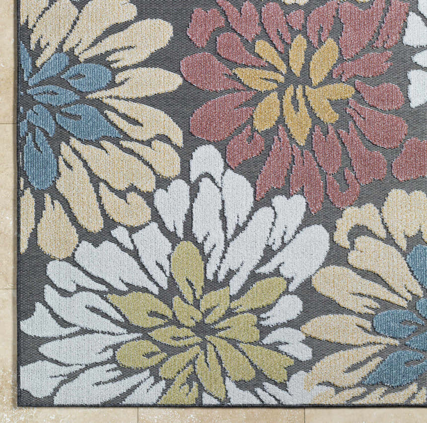 Close-up of Minga Charcoal Area Rug showing floral pattern in charcoal, cream, navy, olive, and rust colors. Corner