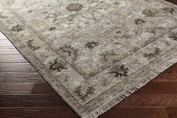 Close-up of the hand-knotted Murchison Area Carpet. Traditional rug with black, cream, light olive, and olive floral pattern. Corner