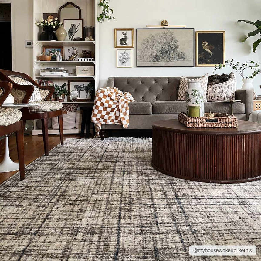 Living room scene with a Taysan Area Rug, gray sofa, round wood coffee table, and gallery wall art. Roomscene-Rectangle