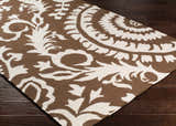 Close-up of the Naeva Area Rug, a hand-woven wool rug in dark brown and white with a contemporary floral pattern. Corner