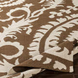 Close-up of the hand woven Naeva Area Rug. Dark brown and walnut floral pattern on 100% wool texture. Fold