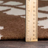 Close-up of Naeva Area Rug showing the pile height with a ruler. Brown wool rug with a cream pattern. Pile